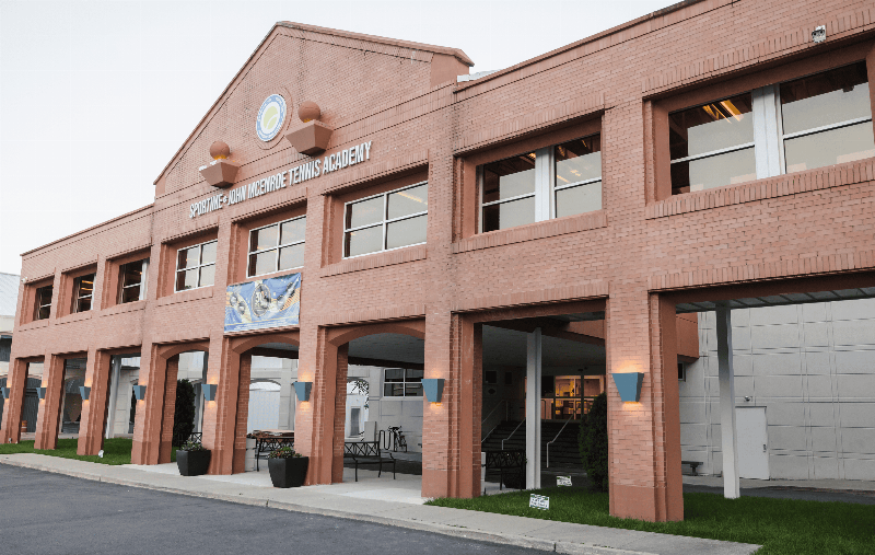 A diverse group of puppies playing and learning in a clean, well-lit indoor training facility on Long Island.
