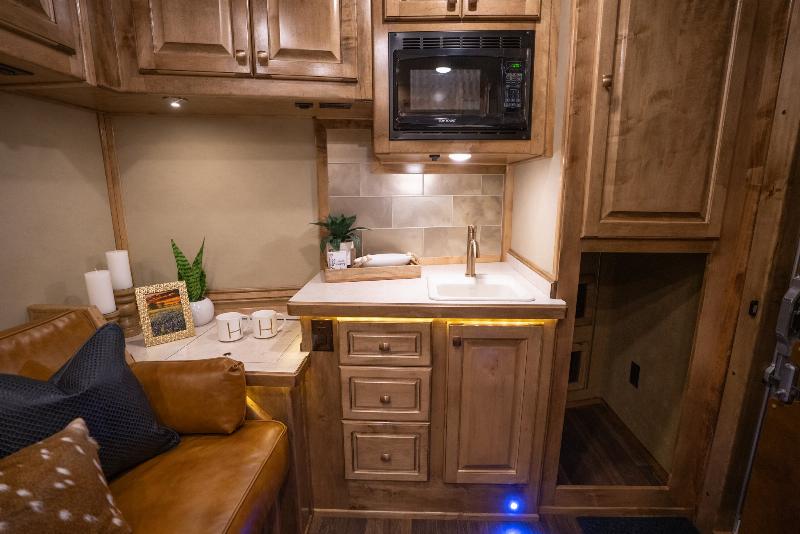 The luxurious interior of a 2 story horse trailer with a cozy loft sleeping area and a modern living space below.