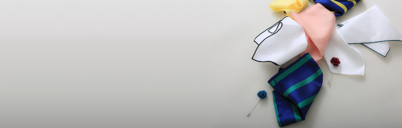 Stylish man wearing a classic navy suit with a patterned tie and pocket square at a horse race