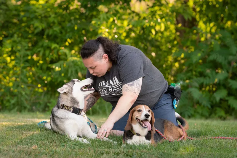 Nora consulting with a dog owner and their Golden Retriever