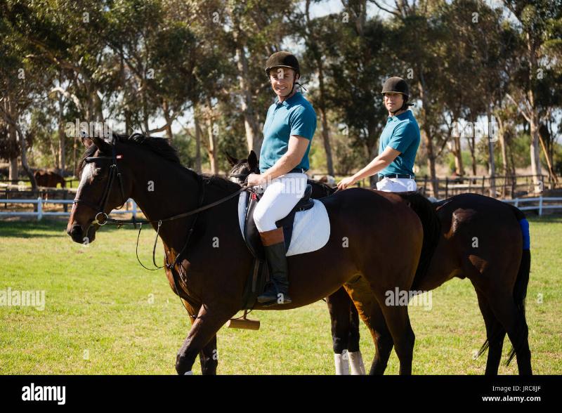 Two thoroughbred horses and their jockeys racing neck and neck towards the finish line at the Pleasanton racetrack, with a crowd visible in the background.