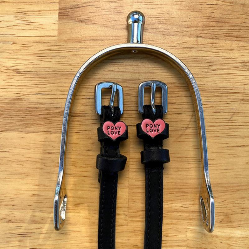 A beautifully detailed Schleich trained horse in a miniature show jumping arena, clearing a colorful jump with a rider on its back.