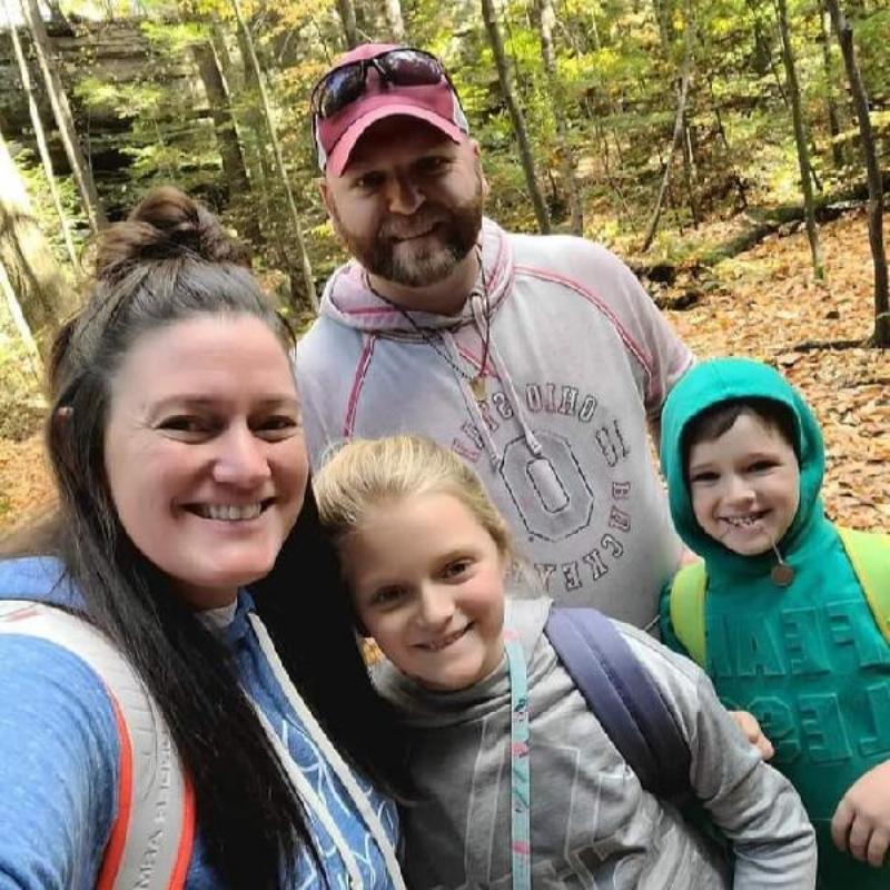 A vibrant, exciting Story of Seasons horse race with four horses mid-race on a dirt track, cheered on by a large crowd under a sunny sky in a pixel art style.