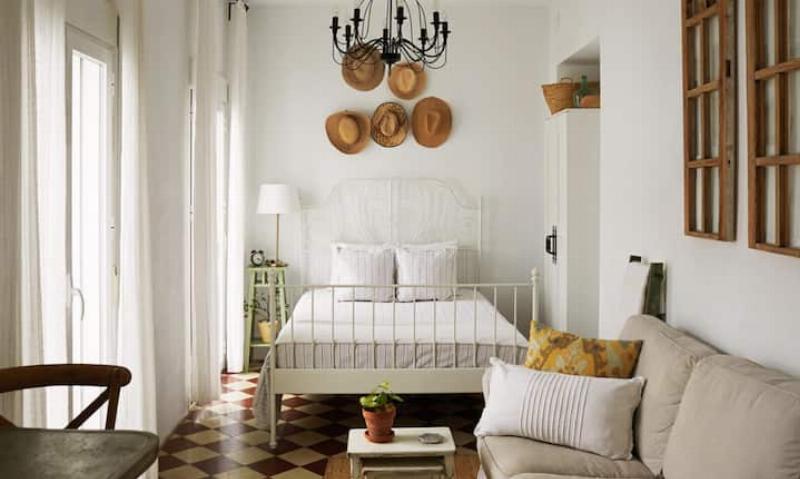Cozy living quarters inside the loft of a two story horse barn, showing rustic wood beams.